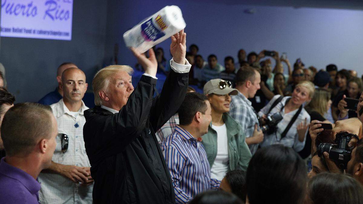 El presidente Donald Trump lanza rollos de papel absorbente a residentes de Puerto Rico afectados por el huracán María, con quienes se reunió el 3 de agosto de 2017 en Guaynabo.