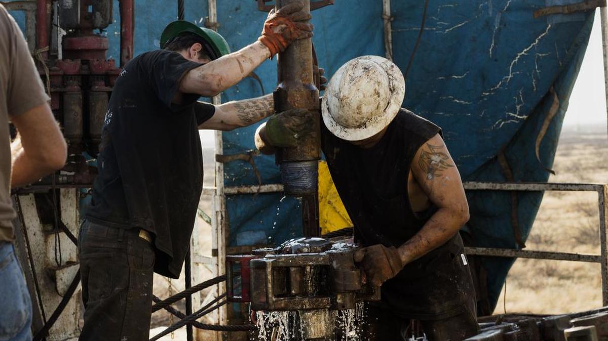 Los trabajadores conectan brocas y collares de perforación, usados para extraer petróleo natural, en la plataforma de perforación Big Dog 22 de Endeavour Energy Resources en la cuenca del Pérmico fuera de Midland, Texas, EEUU, el 12 de diciembre de 2014.
