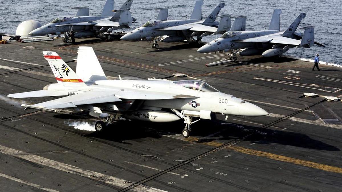 Un avión de combate F-18 aterriza en el portaaviones USS George H.W. Bush mientras viaja hacia el Estrecho de Hormuz.