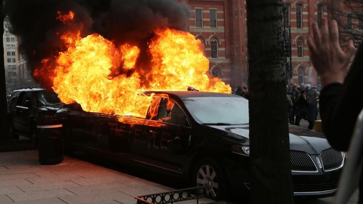 Una limosina arde tras ser vandalizada por manifestantes contra Donal Trump en la Calle K de Washington el viernes.