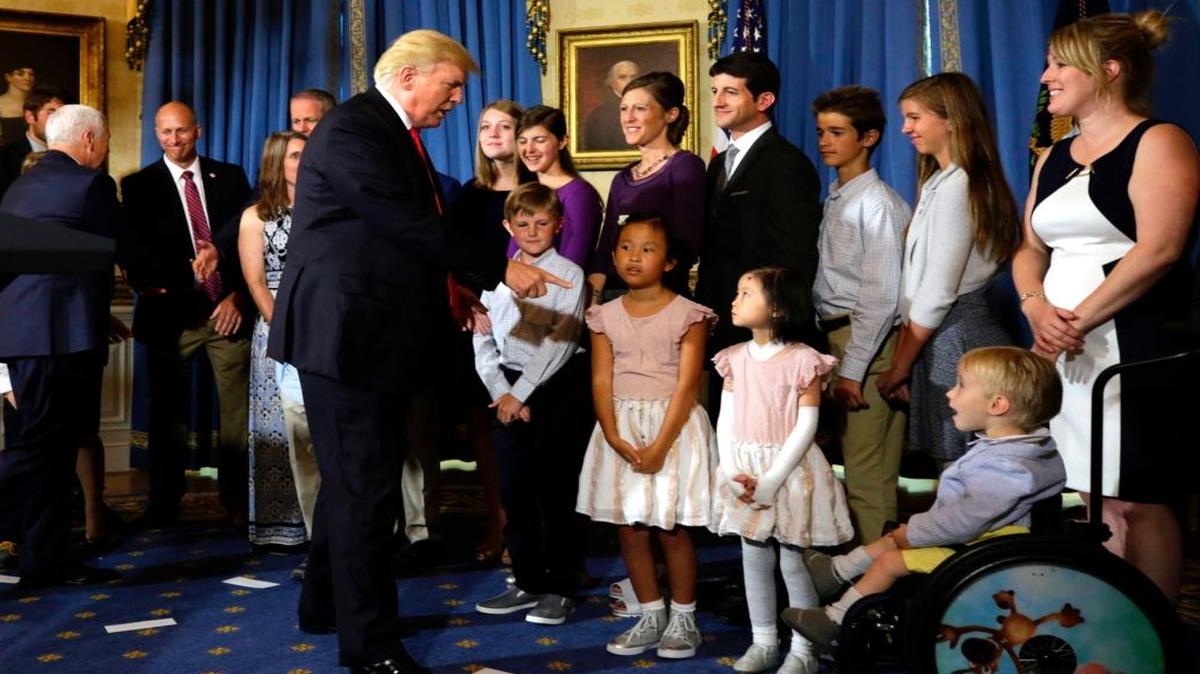 El presidente estadounidense Donald Trump saluda a los niños de las presuntas "víctimas de Obamacare" después de entregar una declaración sobre la asistencia sanitaria en la Casa Blanca en Washington el 24 de julio de 2017.