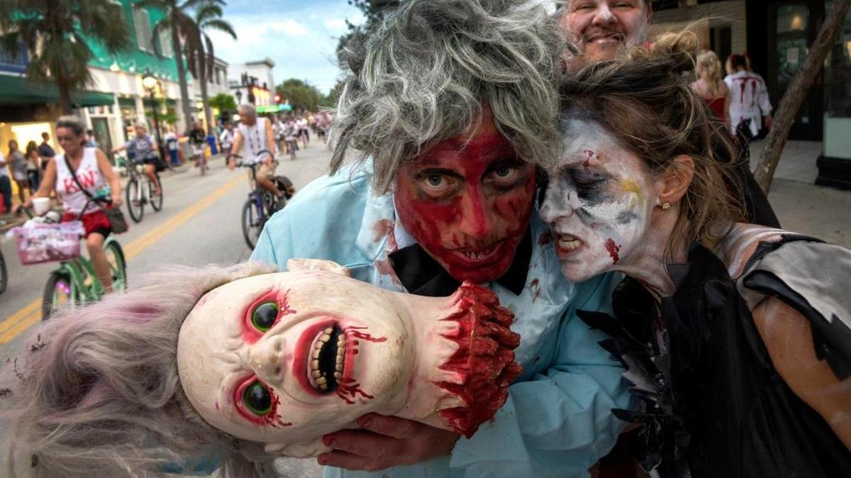 Dave DeSmyter (L) y su esposa Cami (C) asisten al desfile Fantasy Fest 2017 en Key West, Florida, EE. UU., el 22 de octubre de 2017. Fantasy Fest es una fiesta callejera anual de diez días que se celebra en la última semana de Octubre, desde 1979, en Key West, Florida. Cada año, el evento adopta un tema para inspirar a los participantes a crear disfraces y desfiles flotantes.