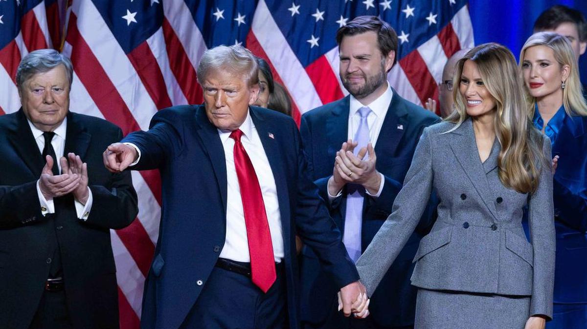Donald Trump se toma de la mano de su esposa, Melania Trump, en su fiesta de observación de la noche de las elecciones en el Centro de Convenciones del Condado de Palm Beach después de ser elegido el 47.º presidente de los Estados Unidos. En la foto también aparecen Viktor Knavs, JD Vance e Ivanka Trump.