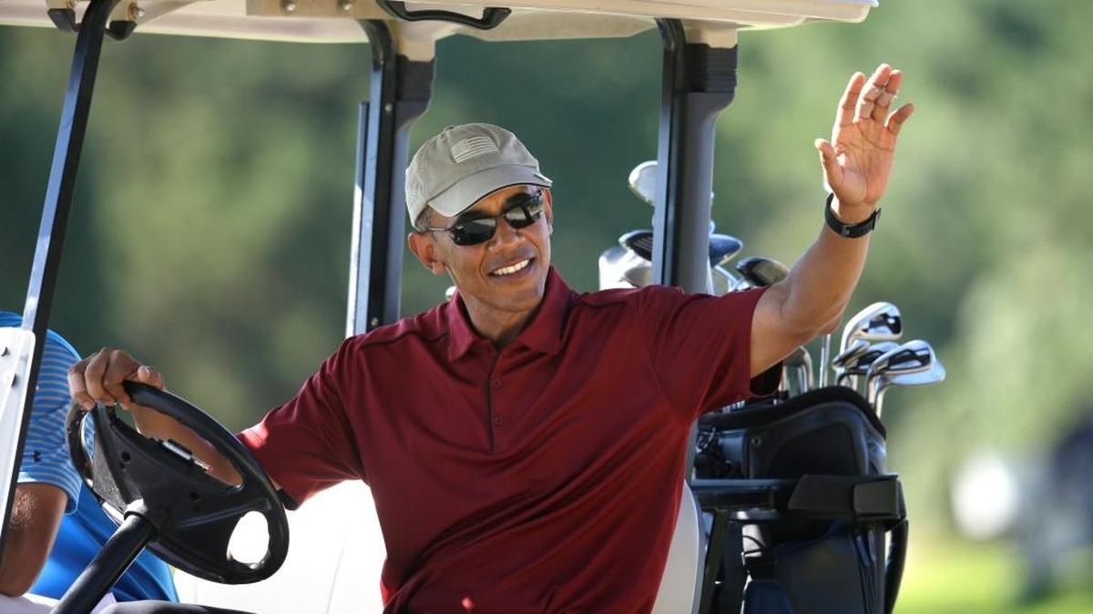 En esta foto de archivo del 14 de agosto de 2015, el presidente Barack Obama saluda desde un carrito de golf mientras juega en el Club de Golf Farm Neck, en Oak Bluffs, Massachussets, durante las vacaciones en la isla de Martha's Vineyard.