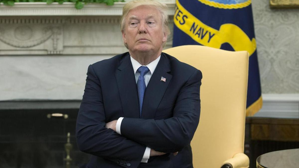 El presidente estadounidense, Donald Trump, y el ex secretario de Estado estadounidense Henry Kissinger (no aparece en la fotografía) conversan con los medios durante un encuentro entre ambos en el Despacho Oval de la Casa Blanca, Washington D.C el 10 de octubre de 2017.