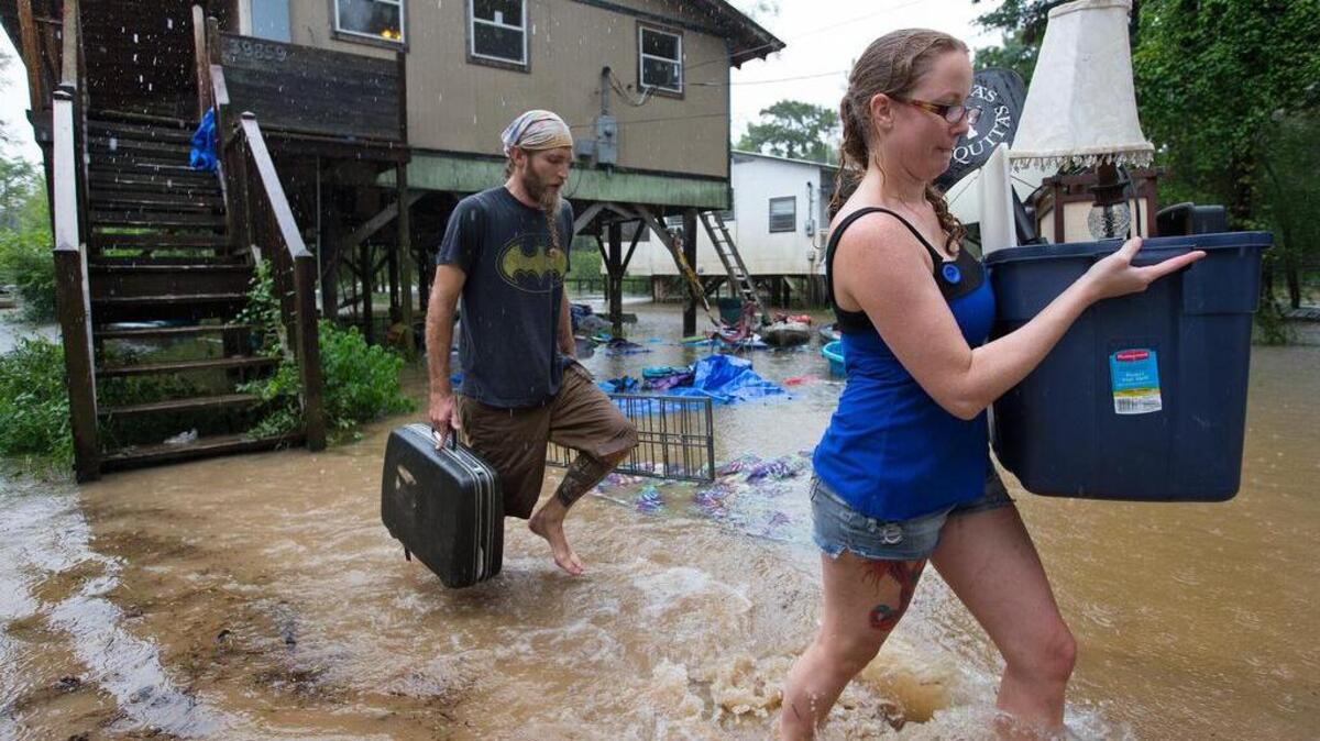 Michael Tramonte y Nikki Conger sacan algunas pertenencias de su casa inundada en Watters Road, Pontchatoula, Louisiana.