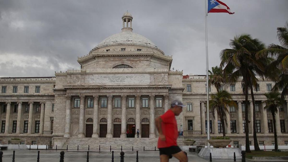 Un hombre cruza corriendo frente al Capitolio de San Juan en julio pasado.