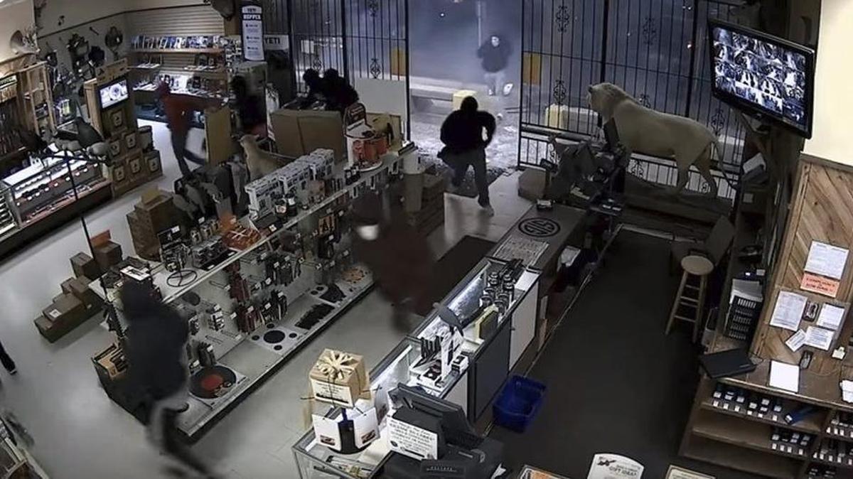 Captura de video que muestra el momento en el que una decena de encapuchados asaltan una tienda de armas en la ciudad de Houston, Texas.