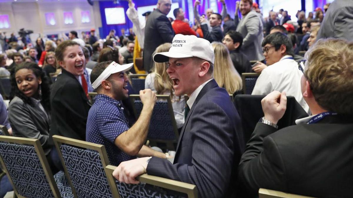Partidarios de las políticas conservadoras y del presidente Trump, hacen callar a una persona que protesta durante el discurso del mandatario en la Conferencia de Acción Política Conservadora en Washington.