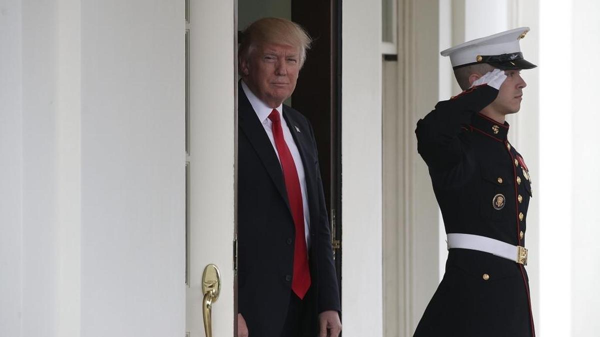 El presidente Donald Trump (izq.) espera para saludar al primer ministro de Dinamarca Lokke Rasmussen en la Casa Blanca, el 30 de marzo.