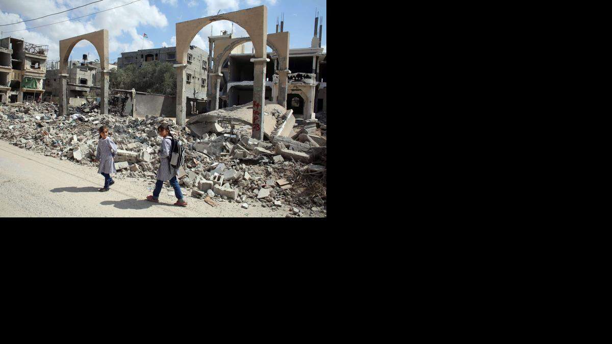 
DOS NIÑAS caminan por una zona en la Franja de Gaza que fue destruida por la respuesta militar israelí a los ataques de Hamas.
