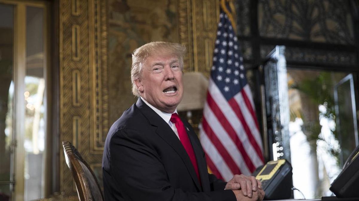 El presidente Donald Trump se dirige a unos periodistas durante una teleconferencia con militares desde su propiedad en Mar-a-Lago, Palm Beach, el domingo 24 de diciembre de 2017.