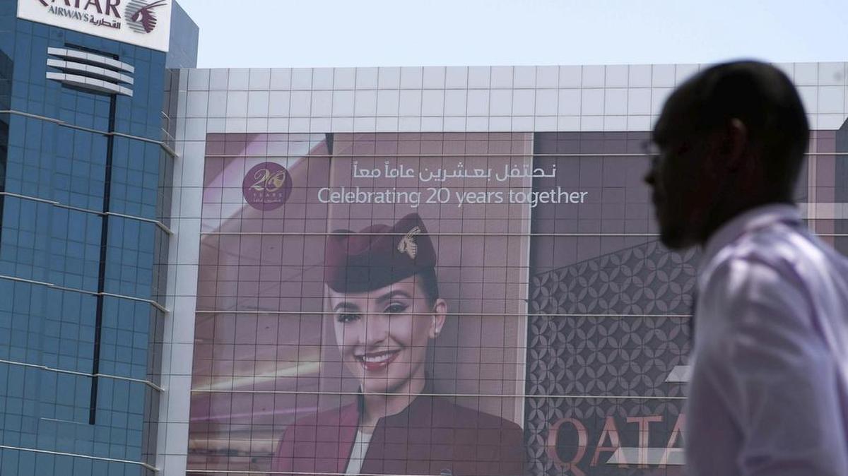 Un hombre pasea frente a la sede de Qatar Airways en Doha, Catar, el 6 de junio de 2017. Los Gobiernos de Arabia Saudí y Baréin retiraron el permiso de operaciones a la aerolínea catarí Qatar Airways y ordenaron el cierre de todas sus oficinas en sus respectivos países en un plazo de 48 horas, un día después de que ambos rompiesen sus relaciones diplomáticas con Doha.