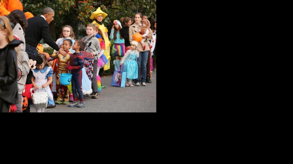 
El presidente Barack Obama da la bienvenida a los niños y los familias militares locales en el Jardín Sur de la Casa Blanca el día de Halloween, en Washington, DC, el 31 de Octubre de 2014.
