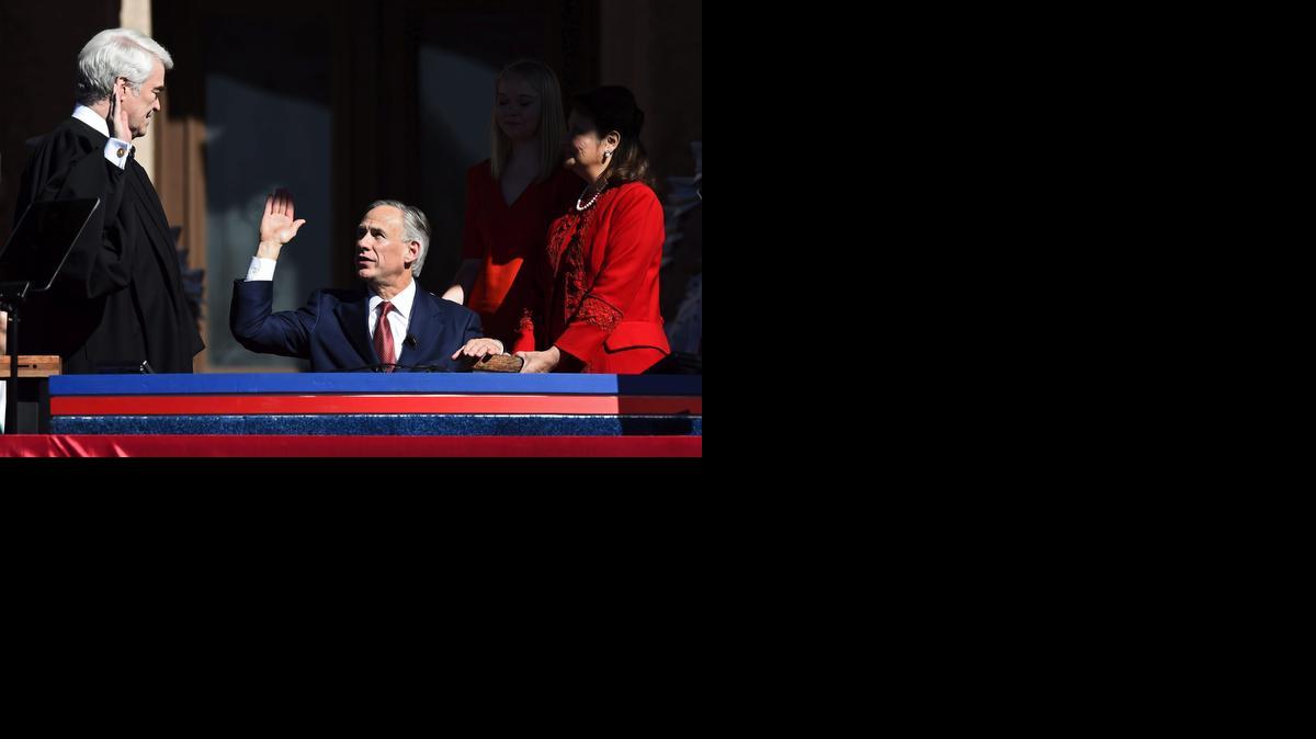 
El republicano y nuevo gobernador de Texas, Gregg Abbott (cen), jura durante la ceremonia de investidura en un escenario situado en las inmediaciones del Capitolio de Texas, en Austin, el martes. 
