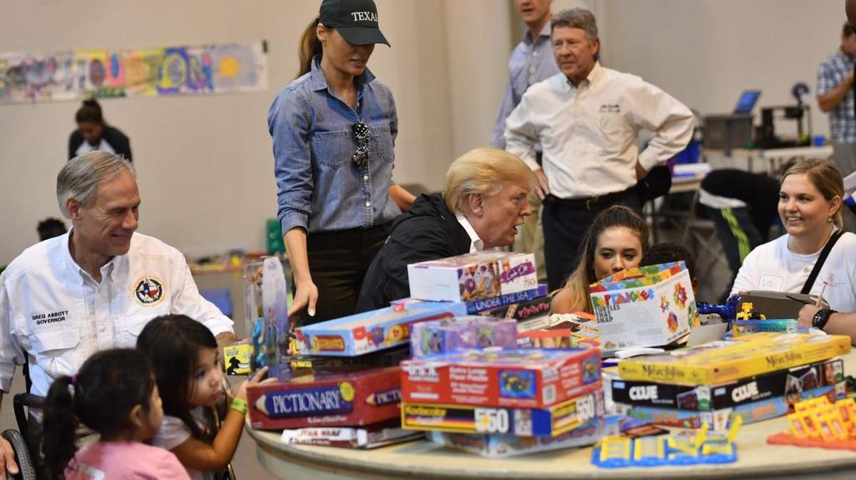 El presidente Donald Trump y la primera dama Melania Trump, acompañados del gobernador de Texas, Greg Abbott (izq.) visitan un centro de asistencia para las víctimas del huracán Harvey el sábado en Houston.
