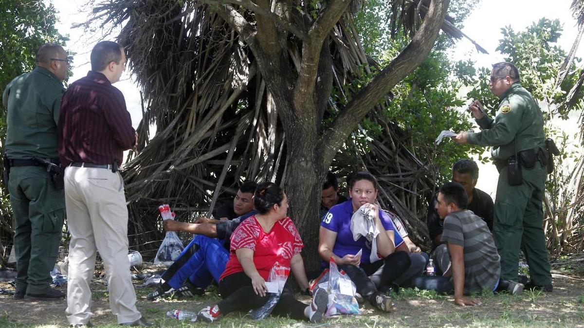 Oficiales de la Patrulla Fronteriza interrogan a un grupo de inmigrantes después de que fueron encontrados en un remolque en Edinburg, Texas el domingo 13 de agosto de 2017.