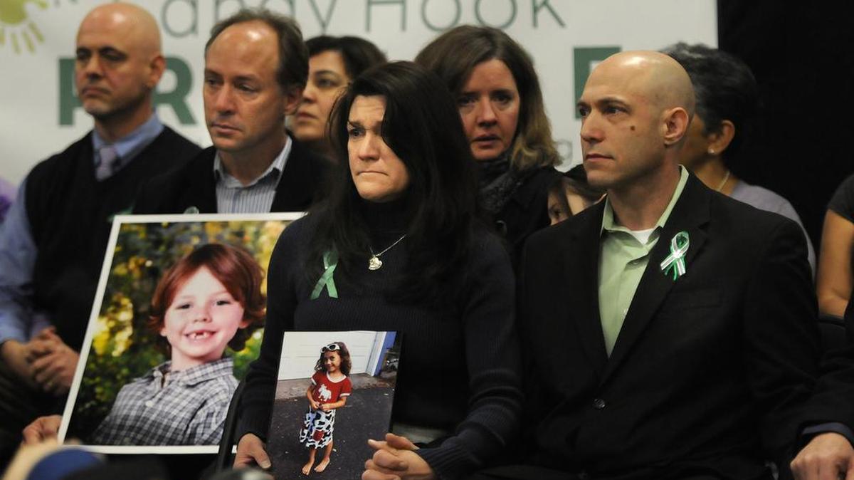 Jeremy Richman, a la derecha, durante una conferencia de prensa el 14 de enero de 2013 junto a su esposa Jennifer Hensel, en el centro, sosteniendo una foto de su hija Avielle, quien fue asesinada en el tiroteo en la Escuela Primaria Sandy Hook el 14 de diciembre de 2012.