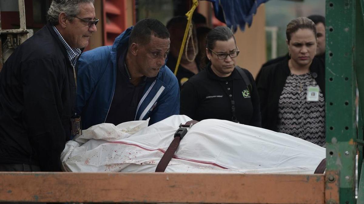Trabajadores forenses y paramédicos trasladan el cuerpo de un hombre que murió tras recibir varios disparos, el pasado jueves 11 de enero en San Juan, Puerto Rico.