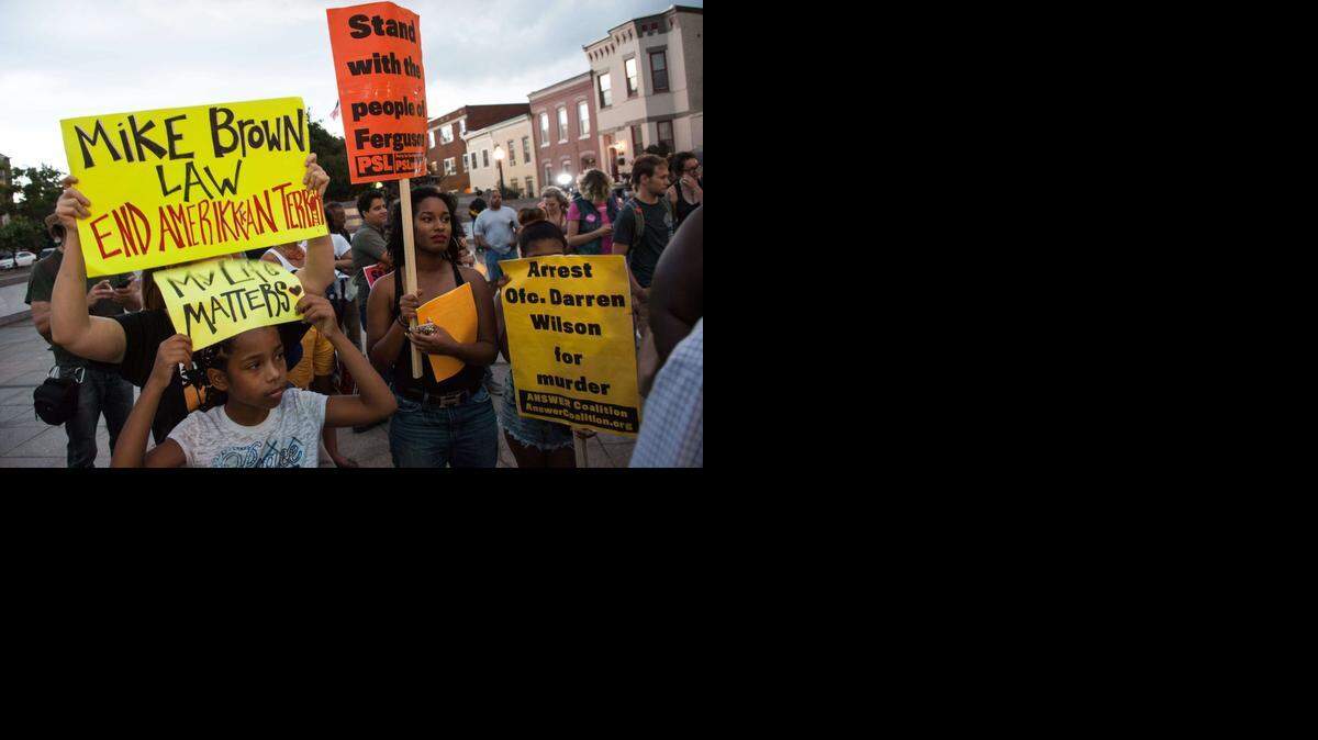 
Personas marchan en Washington el 6 de septiembre de 2014 para protestar por la muerte del adolescente negro Michael Brown a manos de un policía blanco en Ferguson, Missouri.
