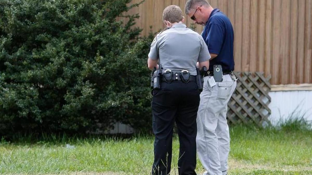 Agentes de policía comparan notas después de hablar con uno de los niños que reportó un intento de secuestro en Fort Mill, Carolina del Sur. La policía luego descubrió que los niños habían inventado la historia para no ir a la escuela.