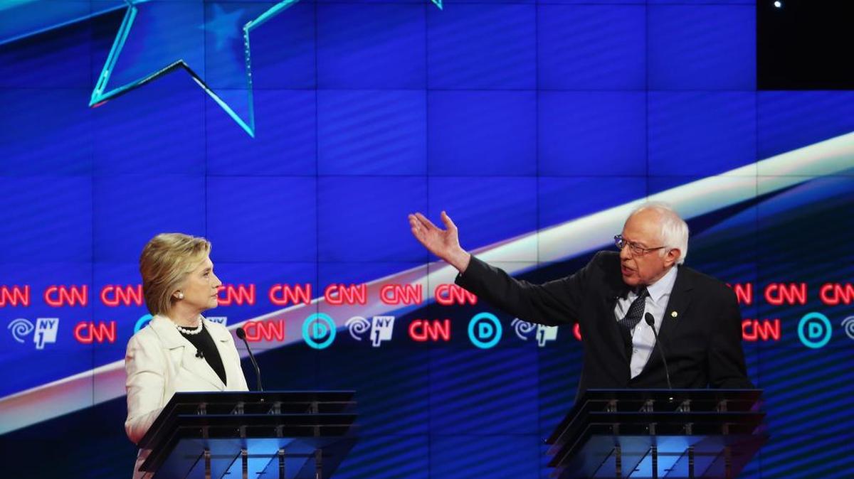 El senador Bernie Sanders, con el brazo en alto, se dirige a la candidata Hillary Clinton en un momento del duro debate entre ambos el jueves en Brooklyn.