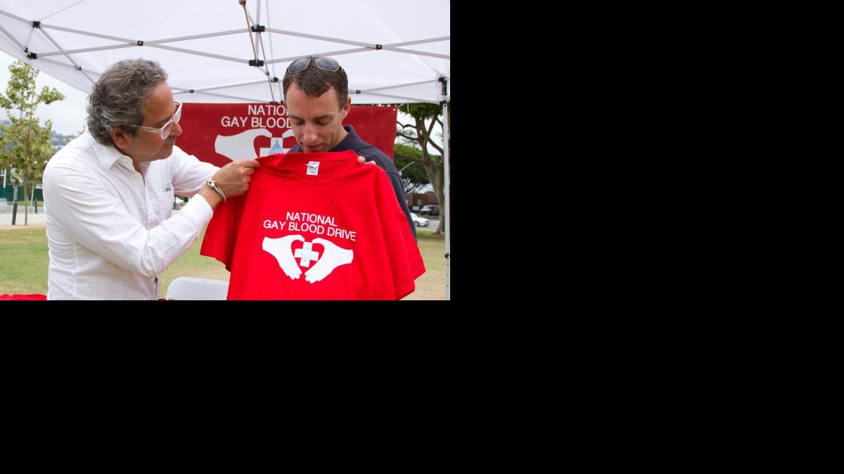 
Participantes en el marcha para que los guys puedan donar sangre, en Los Angeles, muestran una camiseta de esta campaña.

