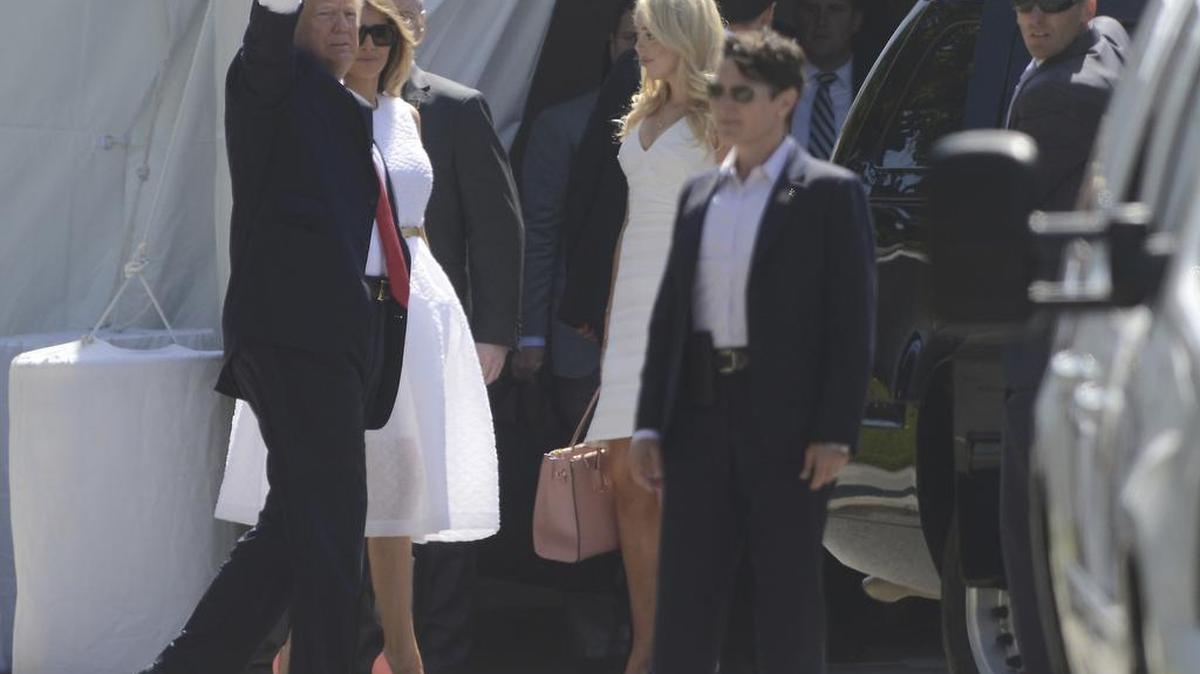 El presidente Donald Trump, acompañado por la primera dama Melania Trump, saluda a los espectadores mientras entra en la Iglesia Episcopal de Bethesda-by-the-Sea en Palm Beach, Florida, para un servicio de Pascua, domingo, 16 de abril de 2017.