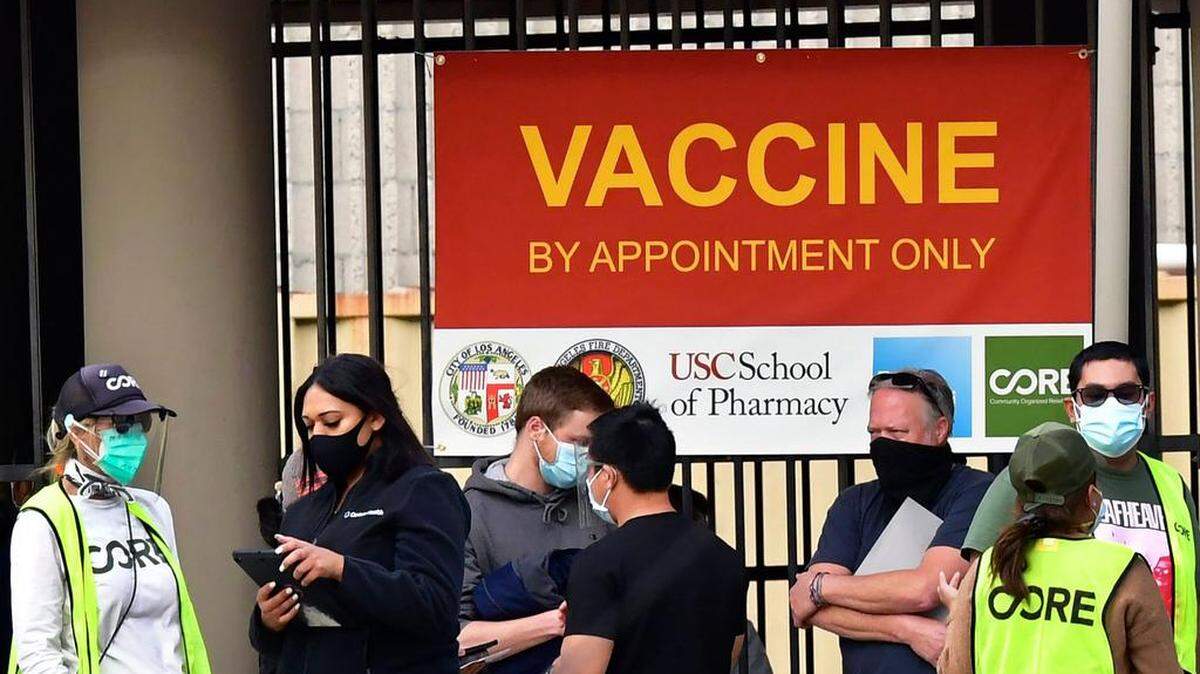 Varias personas con mascarillas hacen fila para recibir la vacuna contra el COVID-19, el 12 de enero de 2021 en Los Ángeles.
