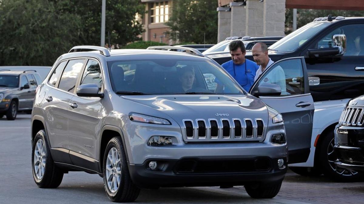 Un vendedor de autos entrega un Jeep Cherokee Limited del 2016 a un cliente en un concesionario Fiat Chrysler, en Doral, Florida.