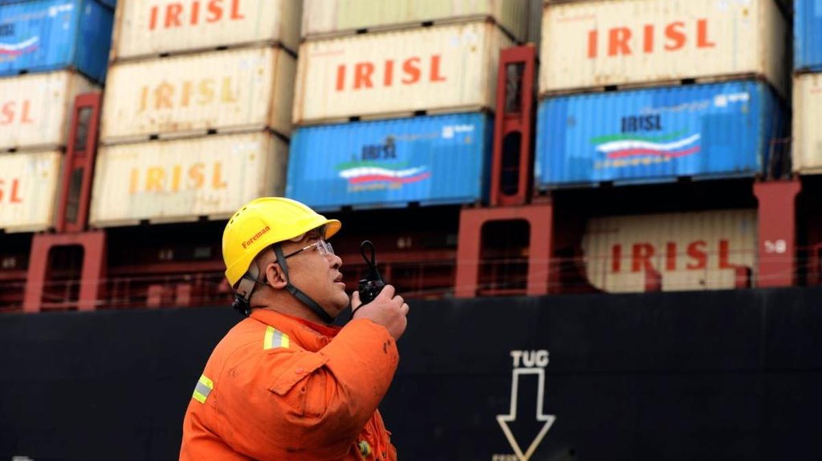 Un trabajador supervisa el martes la descarga de contenedores en un puerto en Qingdao, China. El país asiático es el principal exportador de bienes del planeta, pero sus firmas se han visto golpeadas por la debilidad de sus principales mercados.