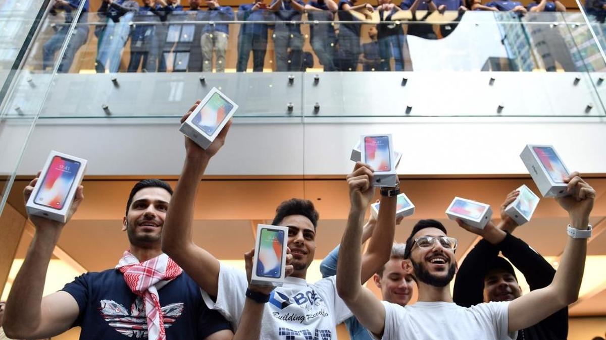 En Sydney, Australia, jóvenes muestran el jueves sus iPhone X de Apple. Ese teléfono inteligente sale a la venta este viernes en otros lugares del mundo.