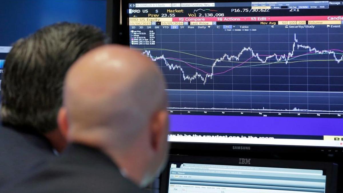 Analistas observan el miércoles una pantalla en la Bolsa de Valores de Nueva York. Las acciones del sector energético estaban ganando por el alza del precio del crudo.