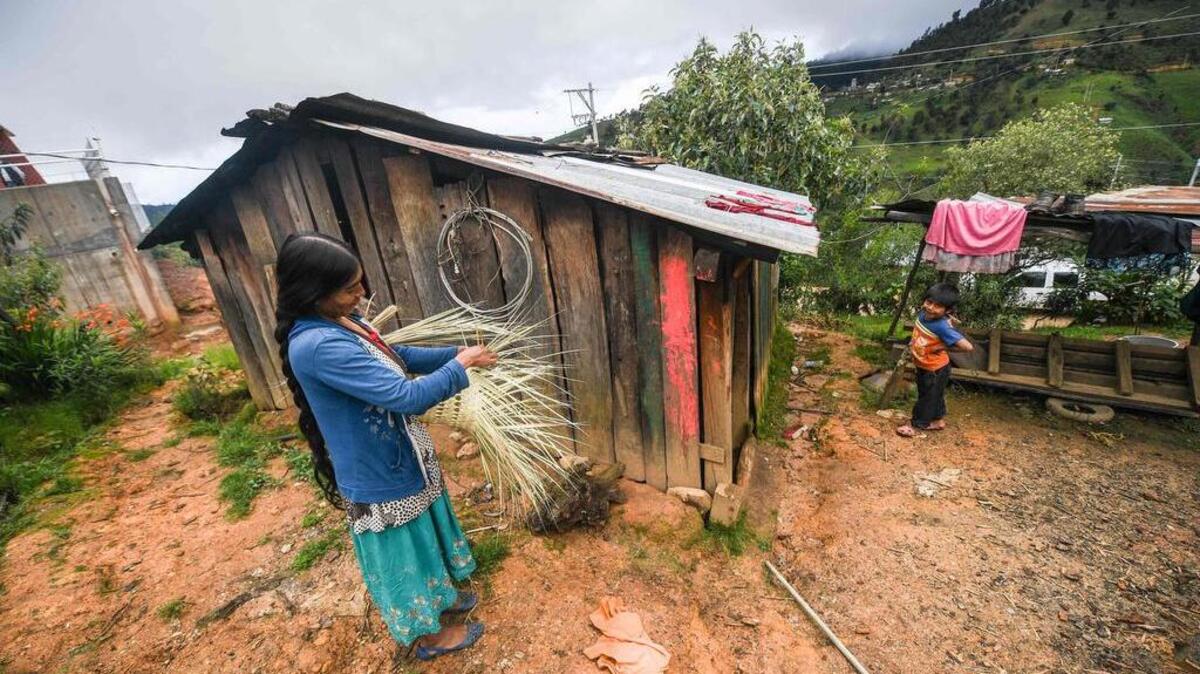 Una mujer hace en una cesta acompañada de su hijo, en San Miguel Amoltepec Viejo, en el estado mexicano de Guerrero, el 8 de septiembre de 2020. El Banco Mundial advierte que por lo menos 115 millones de personas podrían caer en la pobreza extrema debido a la pandemia del coronavirus.