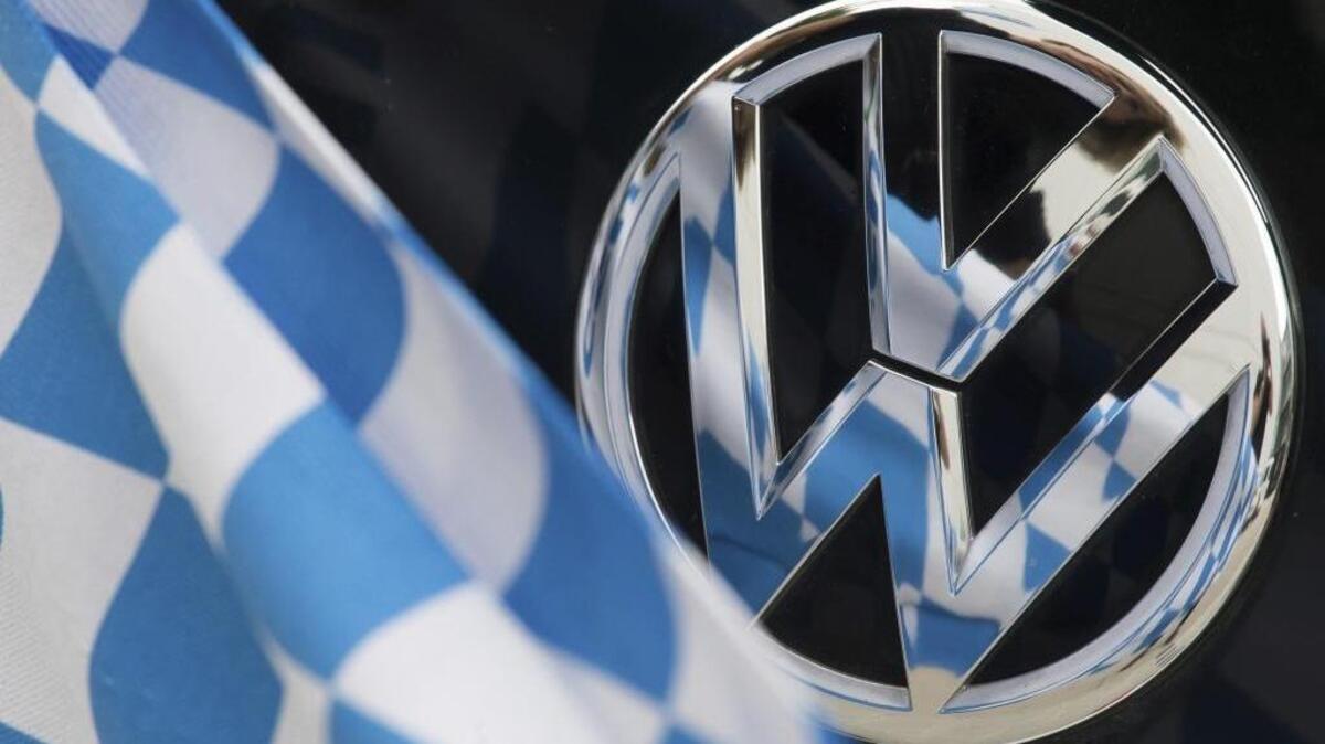 Una bandera de cuadros azules y blancos es reflejada el martes sobre la insignia de un coche Volkswagen, en Múnich. Baviera denunciará a Volkswagen tras verse perjudicada tras el escándalo por la manipulación de motores diésel.