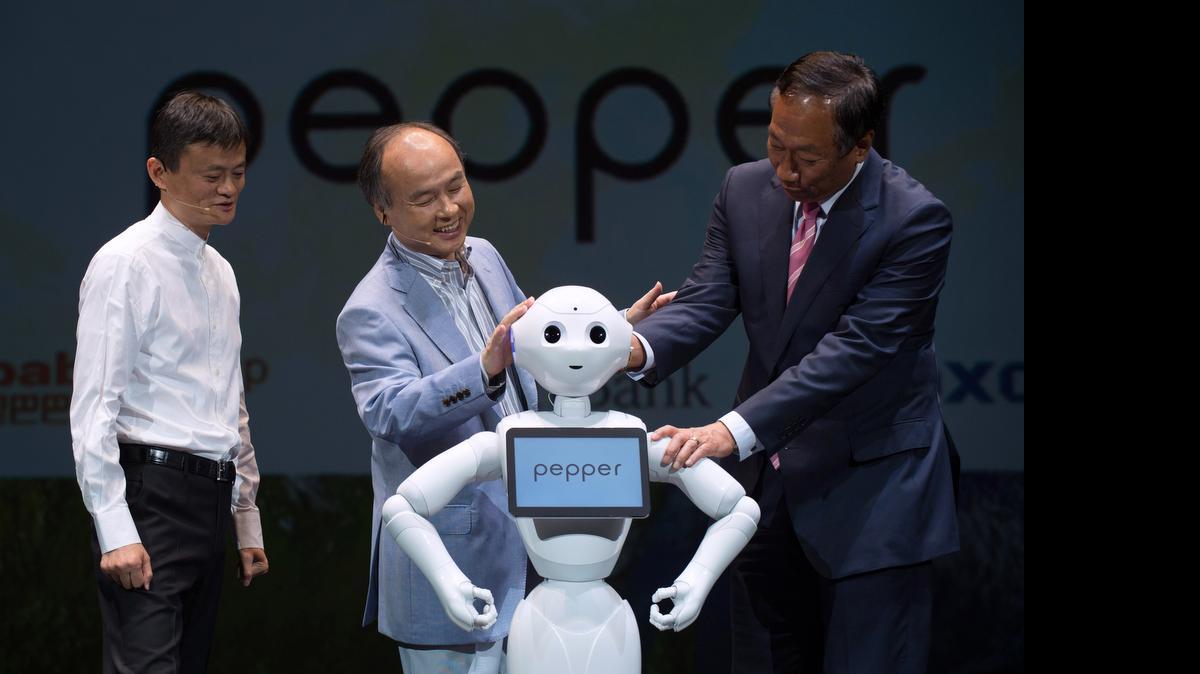 
Los multimillonarios Jack Ma (izq.), presidente del Grupo Alibaba; Masayoshi Son, presidente de SoftBank Corp.; y Terry Gou, presidente de Hon Hai Precision Industry Co., interactúan con el robot humanoide ‘Pepper’ en Urayasu, Japón.
