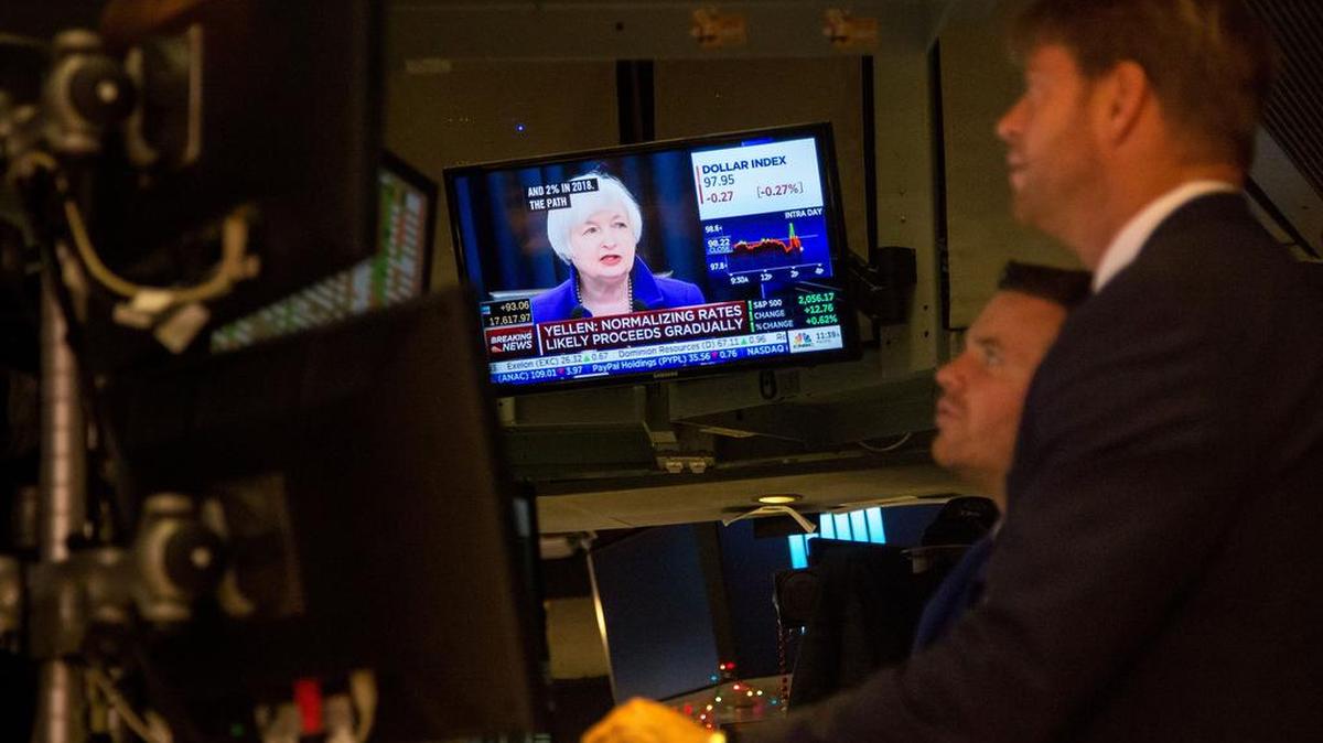 Corredores de la Bolsa de Valores de Nueva York escuchan el discurso de la presidenta de la Reserva Federal, Janet Yellen, sobre las tasas de interés.