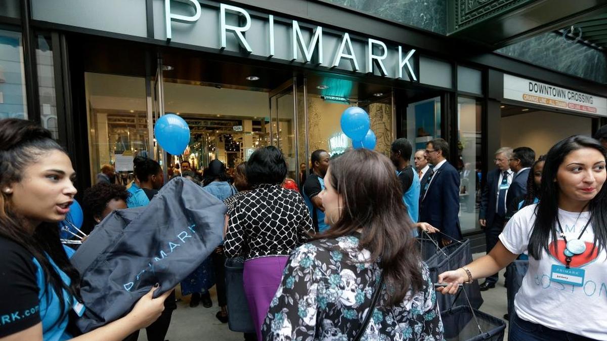 Una empleada de una tienda ofrece en septiembre bolsas a los compradores antes de ingresar en el establecimiento, en Boston.