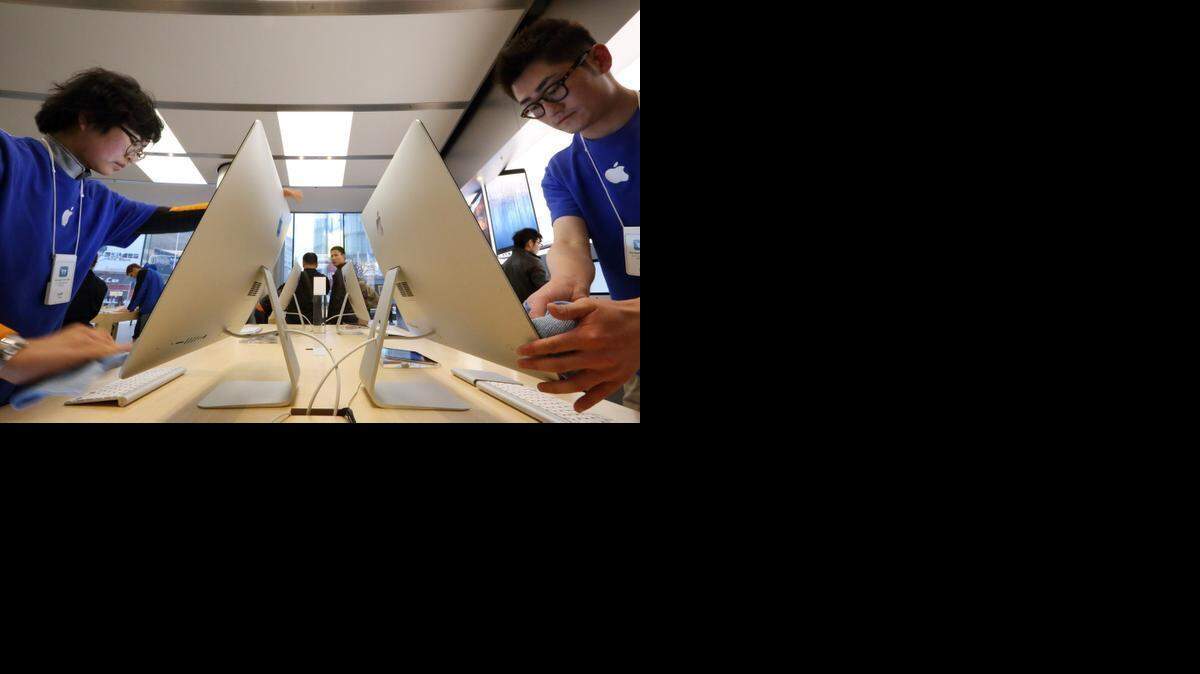 
Empleados de la compañía estadounidense Apple en China en una tienda en Pekín.


