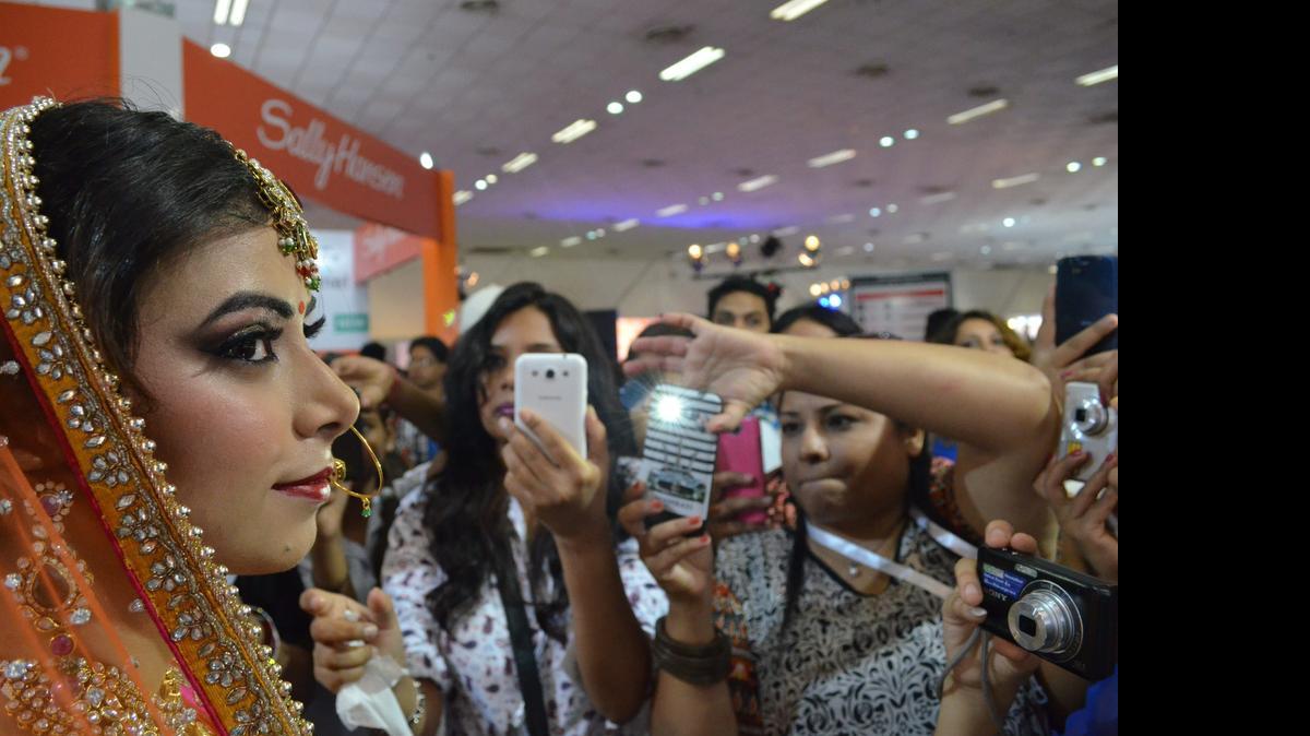 
Una modelo de la empresa Temptu Pro posa para el público después de una sesión de maquillaje en la Feria de Profesionales de la Belleza de la India, en Nueva Delhi.
