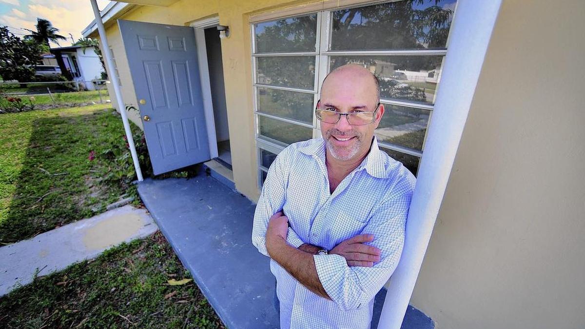 
Lex Levinrad, presidente de Distressed Real Estate Institute, sonríe frente a una casa que acaba de comprar para revender pronto en Lauderhill.
