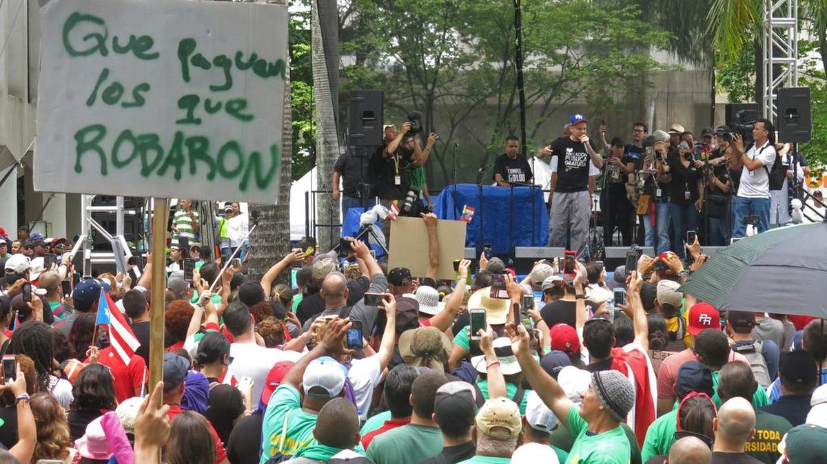 El cantante René Pérez, de Calle 13, habla en San Juan a manifestantes el 1 de mayo del 2017 que protestan por las medidas de austeridad para enfrentar la crisis de Puerto Rico.