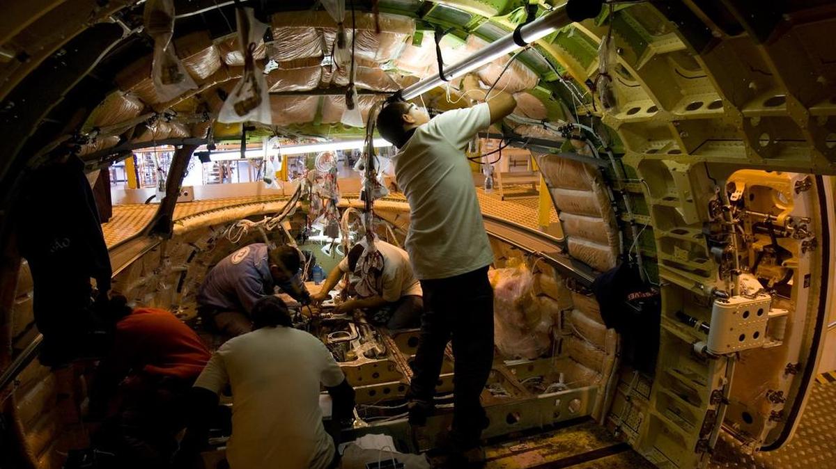 Especialistas de Embraer trabajan en el montaje interno de la cabina de un avión comercial Embraer 190 en la fábrica de Sao Jose dos Campos, Brasil.