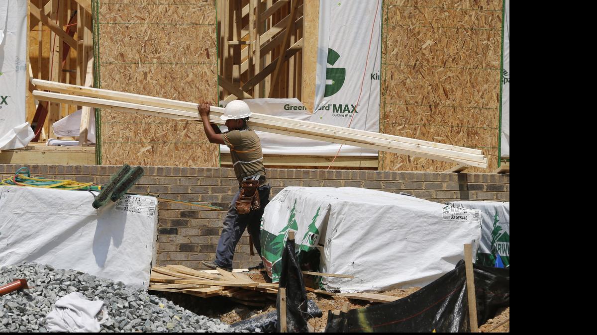 
Un obrero lleva unas tablas en una casa en construcción en Mechanicsville, Virginia, en junio.


