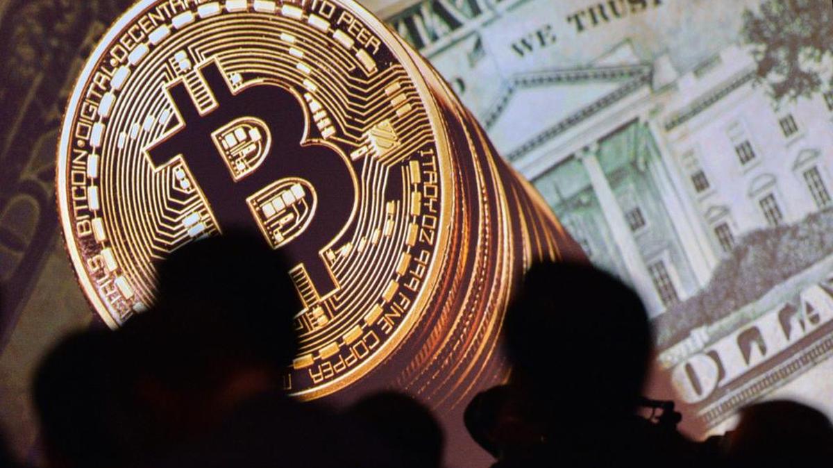 Imagen de un bitcoin y dólares durante el Congreso Mundial del Interpol en Singapur, el 4 de julio de 2017.