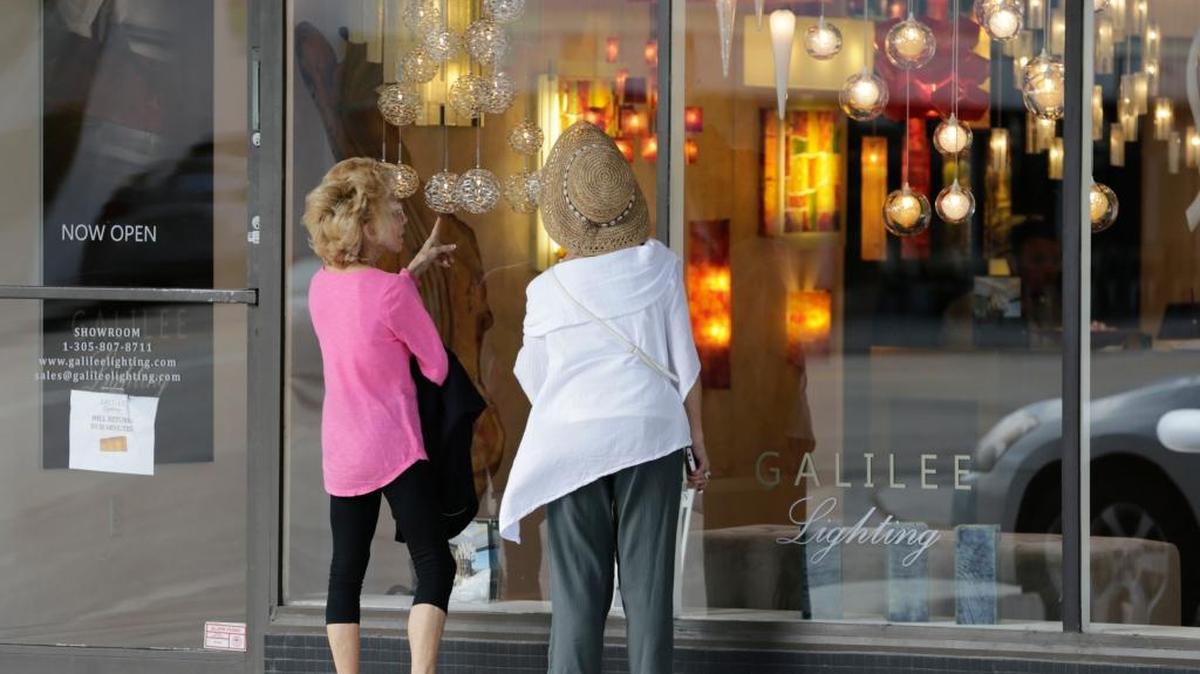 Dos mujeres observan una tienda en Miami Beach. Los gastos de los consumidores, que son tradicionalmente el motor de la economía de EEUU, aumentaron solo en 1.9%, su avance más débil desde el primer trimestre del año pasado. Foto de archivo.