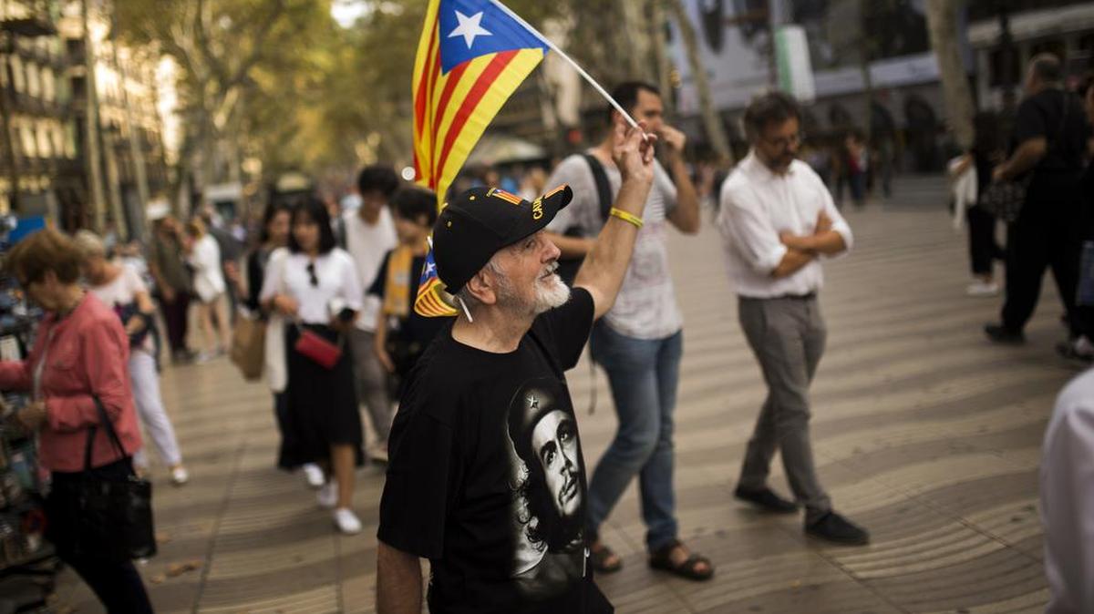 Un hombre que viste una camiseta del comunista argentino Che Guevara, hace ondear la bandera de la independencia de Cataluña en las Ramblas de Barcelona.