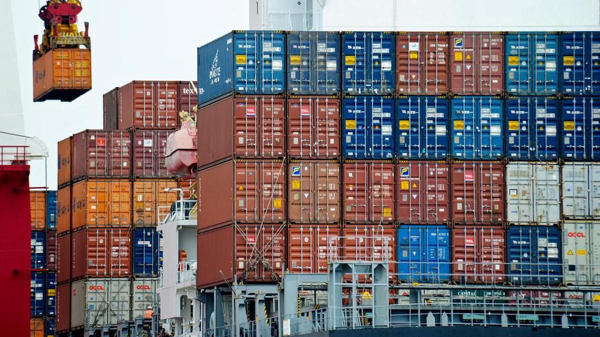 Un contenedor es trasladado hacia un buque de carga en el puerto de Tianjin, en China.
