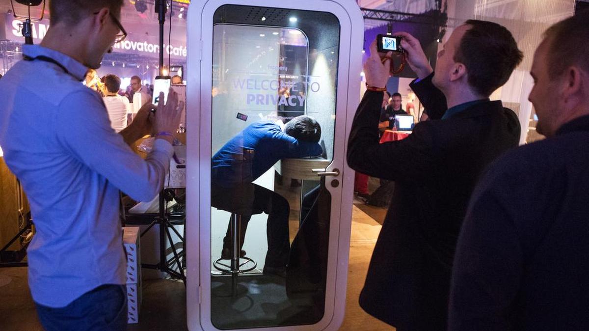 Visitantes toman fotos con sus móviles a una persona que duerme dentro de una cabina privada en el evento Slush en Helsinki, el pasado 30 de noviembre.