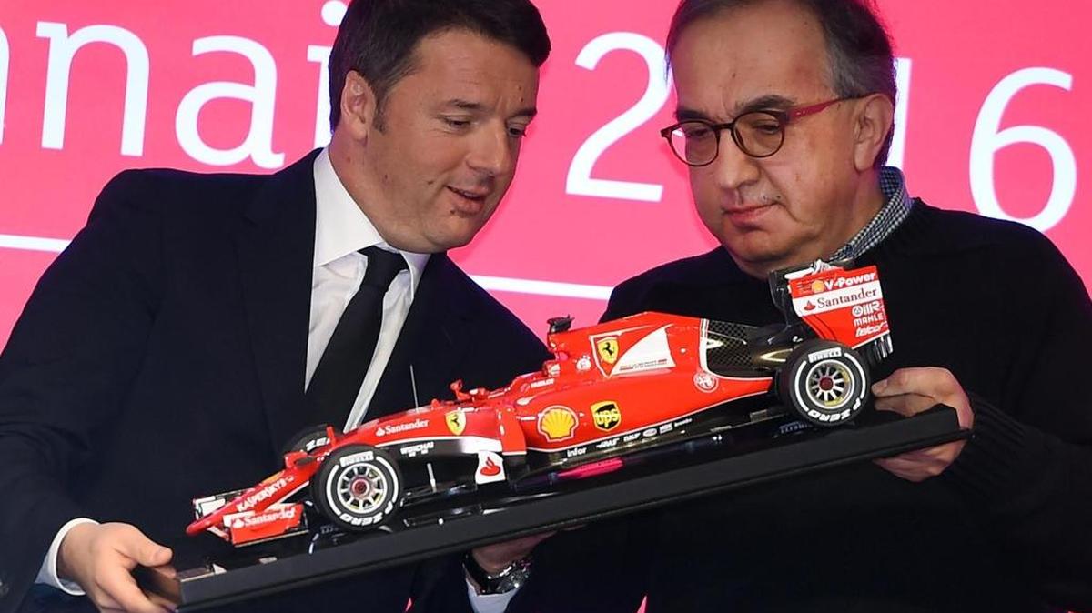 El primer ministro de Italia, Matteo Renzi (izq.), y el presidente de Ferrari, Sergio Marchionne, sostienen una réplica de un modelo F1 en la sede de la Bolsa de Valores de Milán, donde debutó el lunes el fabricante de automóviles deportivos de lujo.